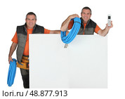 craftsman and his clone phone in hand carrying fluorescent blue hose and. Стоковое фото, агентство Ingram Publishing / Фотобанк Лори