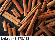 Cinnamon background. Pile of cinnamons stick top view. Cinnamomum cassia close up. Spice for the Holidays. Assortment of spices. Cinnamon bark is a spice used for sweet and savory dish. Стоковое AI-изображение, AI-художник Марина Демидюк / Фотобанк Лори