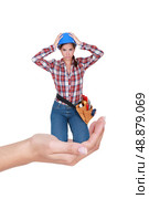 Montage of young female laborer  crouching in a hand. Стоковое фото, агентство Ingram Publishing / Фотобанк Лори