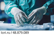 Surgeon prepares surgical instruments in a clinical setting before an operation. Стоковое AI-изображение, AI-художник Александр Довянский / Фотобанк Лори