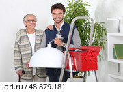 Young man repairing old Lady&rsquo;s lighting. Стоковое фото, агентство Ingram Publishing / Фотобанк Лори