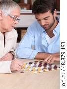 Mother and son playing checkers. Стоковое фото, агентство Ingram Publishing / Фотобанк Лори
