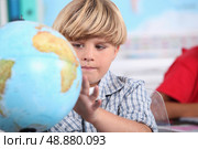 portrait of a pupil with globe. Стоковое фото, агентство Ingram Publishing / Фотобанк Лори