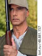 Hunter holding a shotgun close to his face. Стоковое фото, агентство Ingram Publishing / Фотобанк Лори