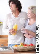 Happy couple stood together in the kitchen. Стоковое фото, агентство Ingram Publishing / Фотобанк Лори