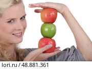 Blonde holding pile of apples. Стоковое фото, агентство Ingram Publishing / Фотобанк Лори