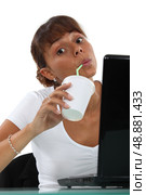 Woman drinking soft drink at desk. Стоковое фото, агентство Ingram Publishing / Фотобанк Лори
