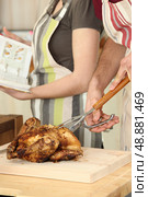 Man cutting chicken on a cutting board. Стоковое фото, агентство Ingram Publishing / Фотобанк Лори