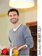 Smiling chap looking at a cookbook. Стоковое фото, агентство Ingram Publishing / Фотобанк Лори