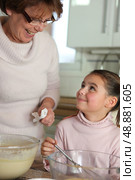 Little girl cooking with grandma. Стоковое фото, агентство Ingram Publishing / Фотобанк Лори