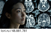 A young woman looks intently at a screen displaying multiple brain scans in a medical setting. Стоковое AI-изображение, AI-художник Данила Большаков / Фотобанк Лори