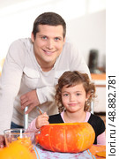 Father and daughter carving pumpkins. Стоковое фото, агентство Ingram Publishing / Фотобанк Лори