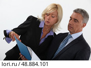 Business professionals discussing a report. Стоковое фото, агентство Ingram Publishing / Фотобанк Лори
