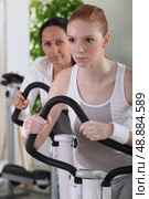 Women using exercise machines at the gym. Стоковое фото, агентство Ingram Publishing / Фотобанк Лори
