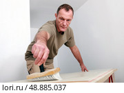 Man sweeping a wooden surface. Стоковое фото, агентство Ingram Publishing / Фотобанк Лори