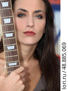 Unfriendly woman posing with her guitar. Стоковое фото, агентство Ingram Publishing / Фотобанк Лори