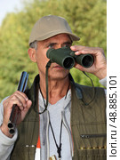 Hunter looking through binoculars. Стоковое фото, агентство Ingram Publishing / Фотобанк Лори