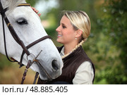 Young woman patting her horse. Стоковое фото, агентство Ingram Publishing / Фотобанк Лори