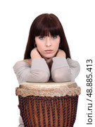 Brunette leaning on bongo drum. Стоковое фото, агентство Ingram Publishing / Фотобанк Лори