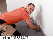 Man laying a linoleum floor. Стоковое фото, агентство Ingram Publishing / Фотобанк Лори