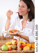 Health conscious brunette eating fruit salad. Стоковое фото, агентство Ingram Publishing / Фотобанк Лори