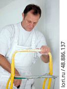 Decorator covering roller with paint. Стоковое фото, агентство Ingram Publishing / Фотобанк Лори