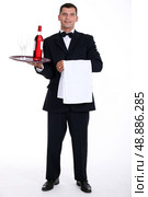 Waiter holding tray with wine bottle. Стоковое фото, агентство Ingram Publishing / Фотобанк Лори