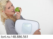 Woman with apple and scales. Стоковое фото, агентство Ingram Publishing / Фотобанк Лори