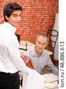 Waiter serving a bottle of rose to a male diner in a restaurant. Стоковое фото, агентство Ingram Publishing / Фотобанк Лори