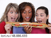 A group of friends eating a long sandwich. Стоковое фото, агентство Ingram Publishing / Фотобанк Лори