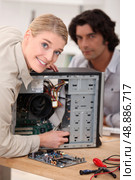 Couple attempting to repair computer. Стоковое фото, агентство Ingram Publishing / Фотобанк Лори