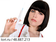 nurse with helmet haircut holding syringe. Стоковое фото, агентство Ingram Publishing / Фотобанк Лори