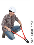 Man kneeling with bolt-cutters. Стоковое фото, агентство Ingram Publishing / Фотобанк Лори