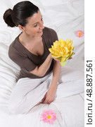 woman sitting cross-legged with water lily. Стоковое фото, агентство Ingram Publishing / Фотобанк Лори