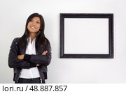 Young woman stood by empty picture frame. Стоковое фото, агентство Ingram Publishing / Фотобанк Лори