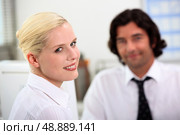 Smiling woman sitting with a colleague. Стоковое фото, агентство Ingram Publishing / Фотобанк Лори