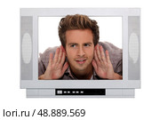Man stuck in a television screen and struggling to hear. Стоковое фото, агентство Ingram Publishing / Фотобанк Лори