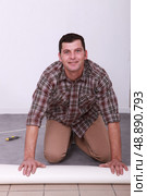 Man unrolling carpet. Стоковое фото, агентство Ingram Publishing / Фотобанк Лори
