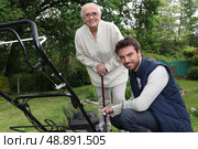 Son helping Mother in the garden. Стоковое фото, агентство Ingram Publishing / Фотобанк Лори