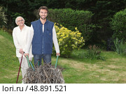 Son pushing wheel-barrow. Стоковое фото, агентство Ingram Publishing / Фотобанк Лори