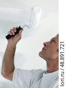 Decorator repainting ceiling. Стоковое фото, агентство Ingram Publishing / Фотобанк Лори