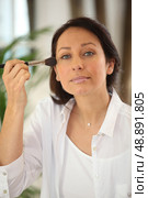 Thirty years old woman applying blush. Стоковое фото, агентство Ingram Publishing / Фотобанк Лори