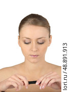 Woman with bare shoulders looking at a lipstick. Стоковое фото, агентство Ingram Publishing / Фотобанк Лори