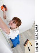 Woman using a tape measurer. Стоковое фото, агентство Ingram Publishing / Фотобанк Лори