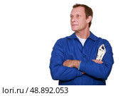 Labourer stood with arms folded holding wrench. Стоковое фото, агентство Ingram Publishing / Фотобанк Лори