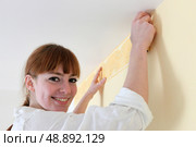 Female decorator hanging wallpaper border. Стоковое фото, агентство Ingram Publishing / Фотобанк Лори