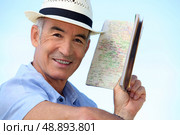 Man looking at an atlas. Стоковое фото, агентство Ingram Publishing / Фотобанк Лори