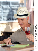 Elderly man drinking a glass of rose in a cafe. Стоковое фото, агентство Ingram Publishing / Фотобанк Лори