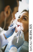 A dentist examines a patients teeth with a dental mirror and probe during a routine oral checkup. Стоковое AI-изображение, AI-художник Данила Большаков / Фотобанк Лори