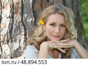 Portrait of woman in front of tree trunk. Стоковое фото, агентство Ingram Publishing / Фотобанк Лори